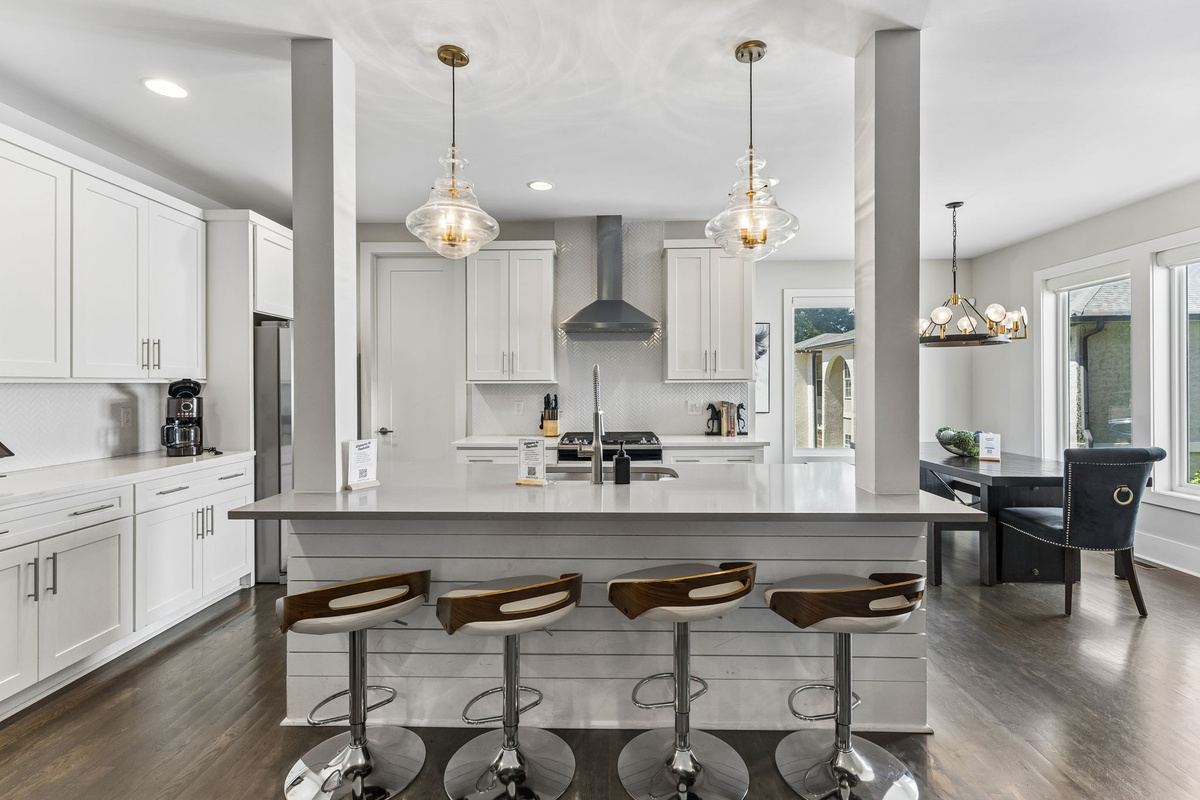 Gather around the quartz island &mdash; bar seating for four, gas range behind, and everything a group of ten needs to cook together.