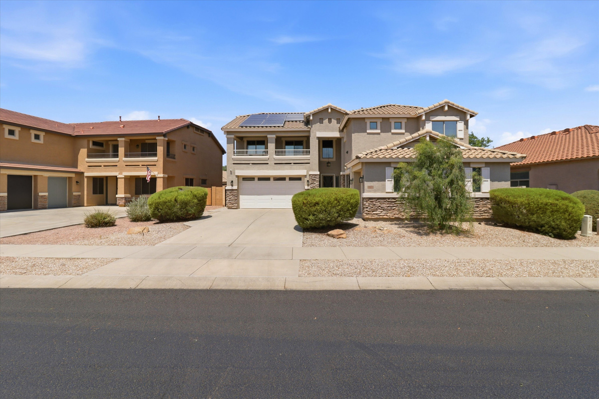 Front exterior with driveway parking, garage access, and a low-maintenance desert yard.
