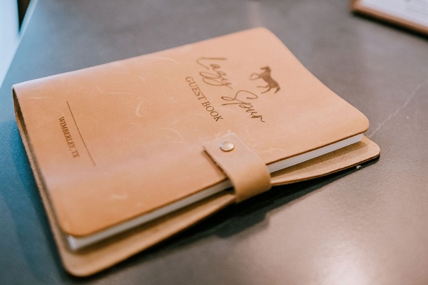 The Lazy Spur Suite guestbook &mdash; leave a note for the next traveler in a leather-bound keepsake at Gaines Ranch on the Square.