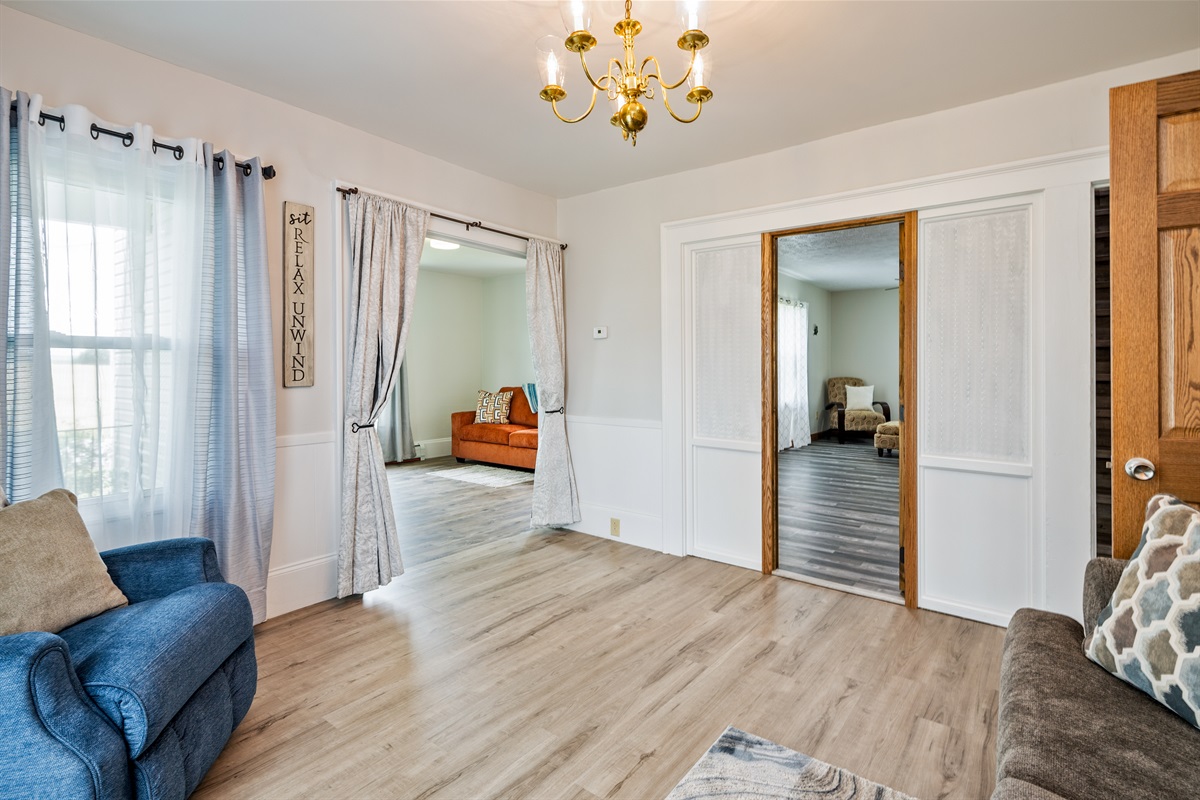 Step into this bright and inviting living area featuring stylish wood floors and dual entryways to multiple lounges—ideal for gathering and relaxing.