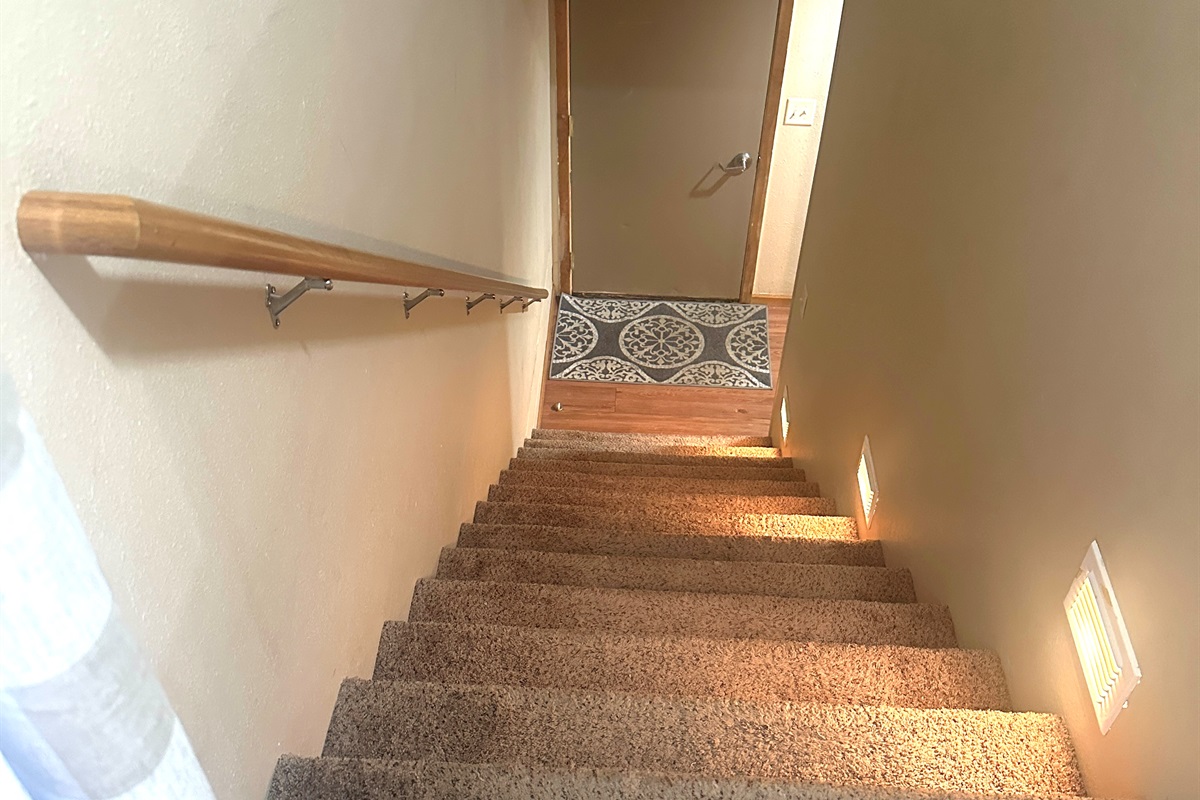 The bedrooms are down the stairs from the kitchen.
