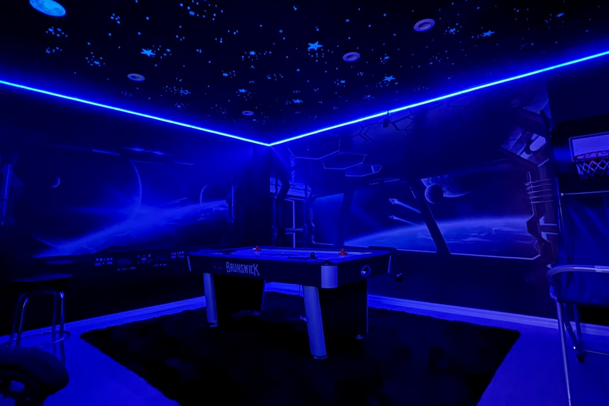 Immersive galactic walls and lighting make every moment in this game room unforgettable.