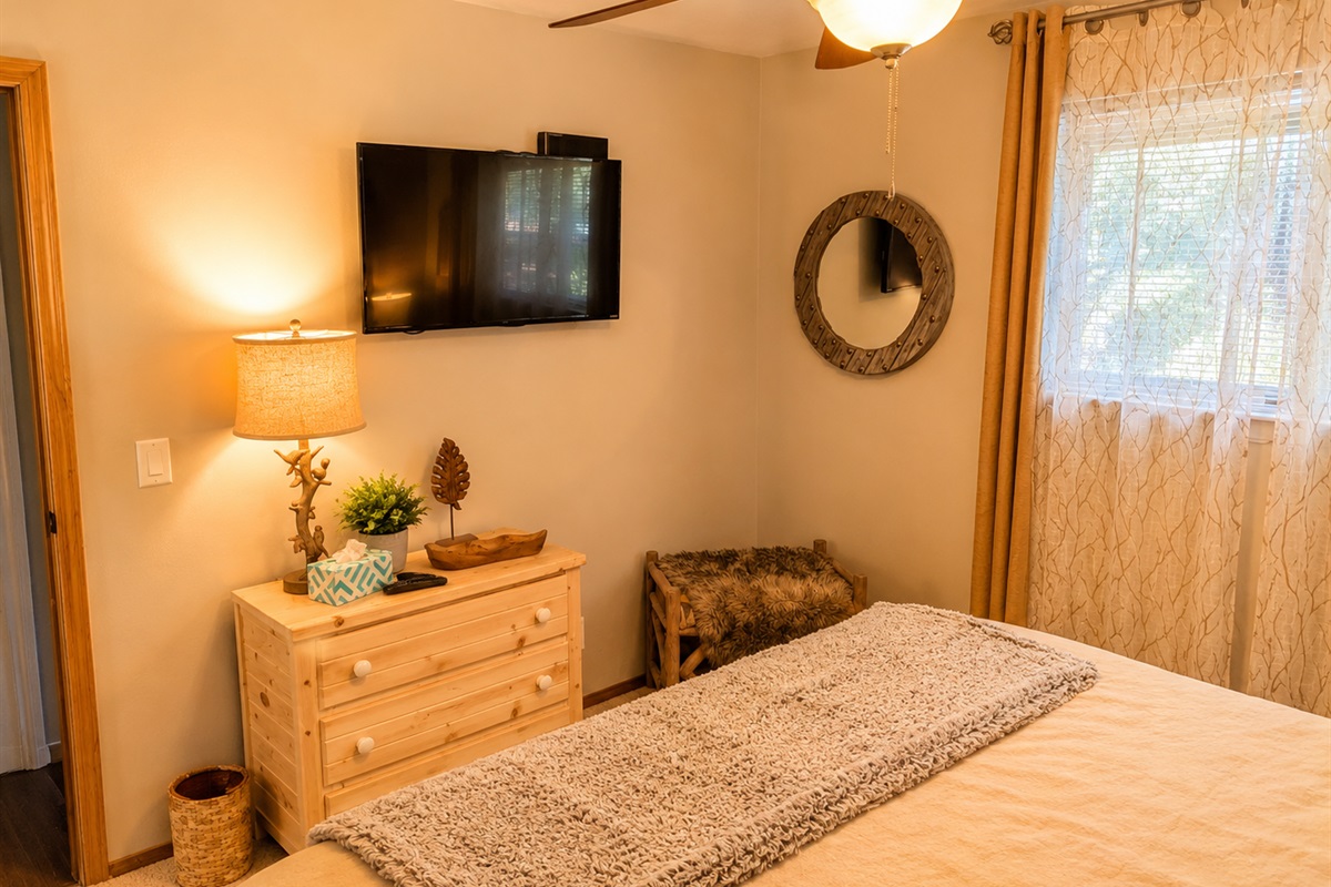 The second downstairs bedroom has a small dresser, luggage rack/bench and closet for storage.