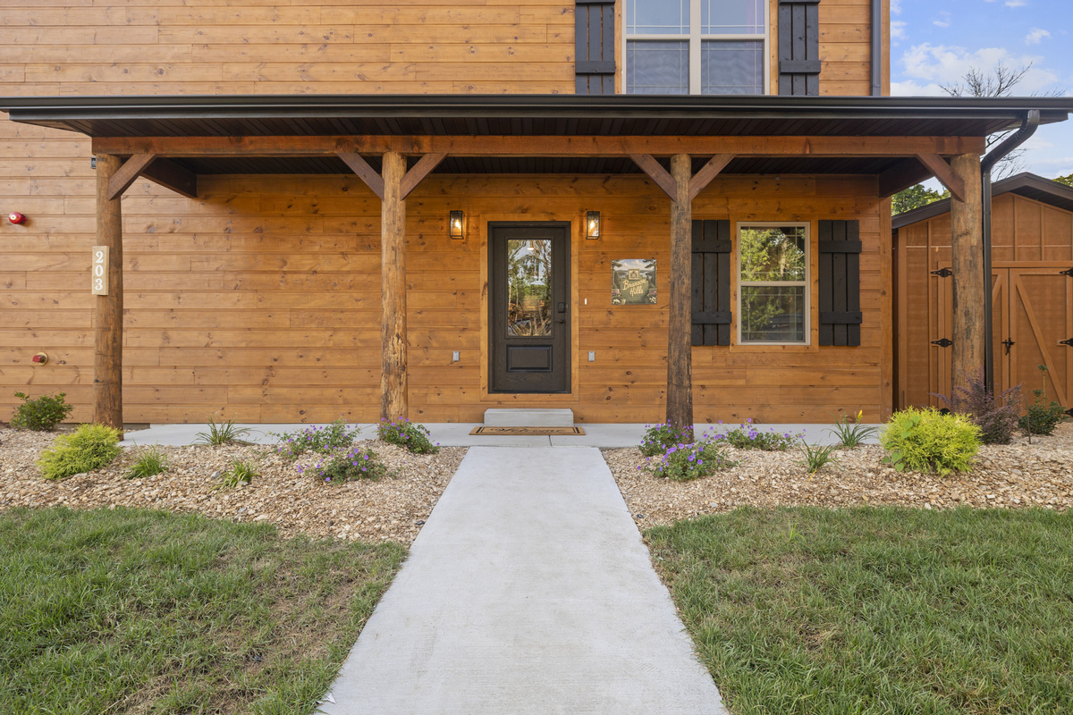 Timber posts frame the covered front porch and the walk up to the door.