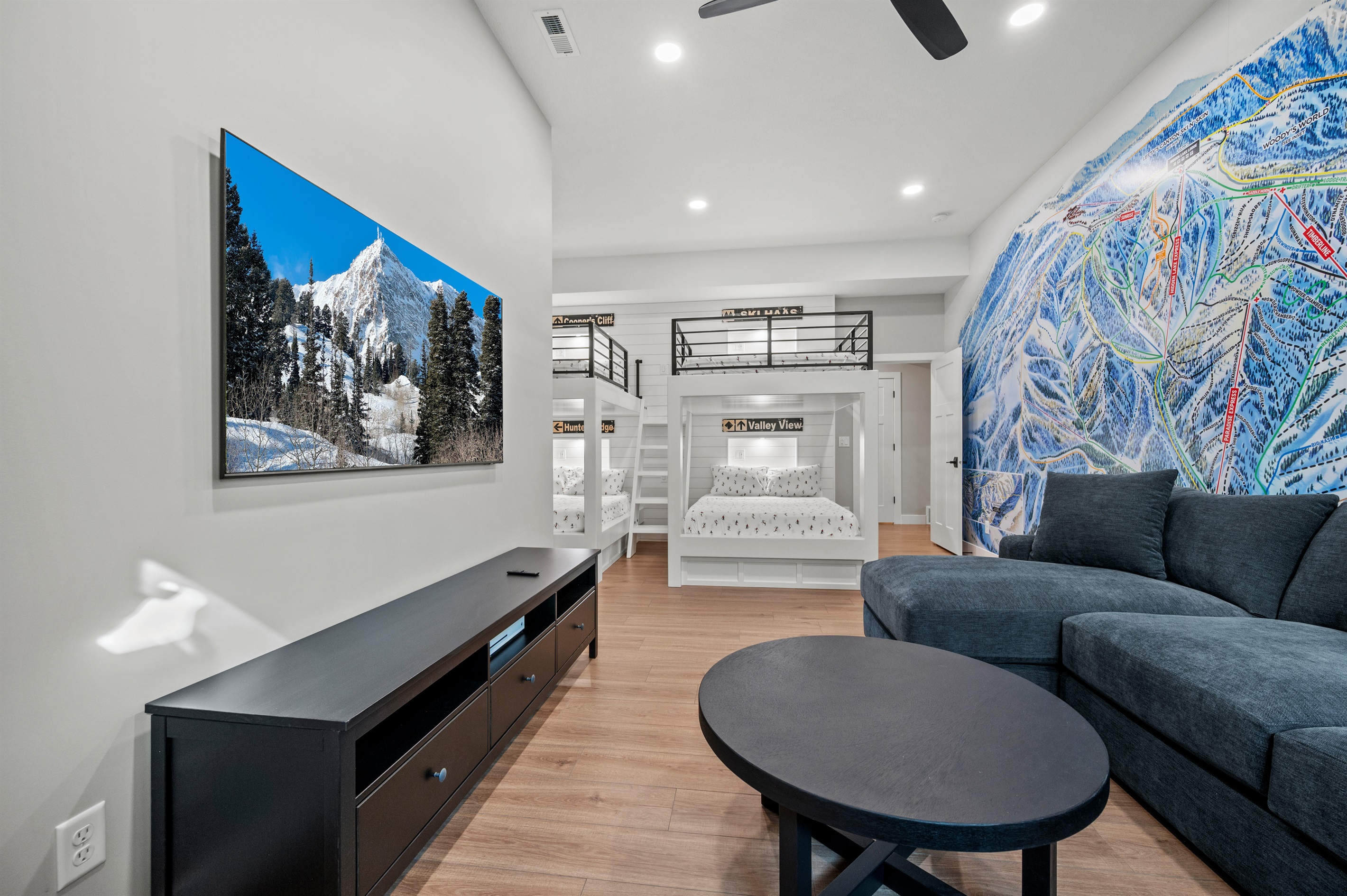 Bunkroom lounge featuring a large sectional sofa and a smart TV—ideal for movies, games, and relaxing together.