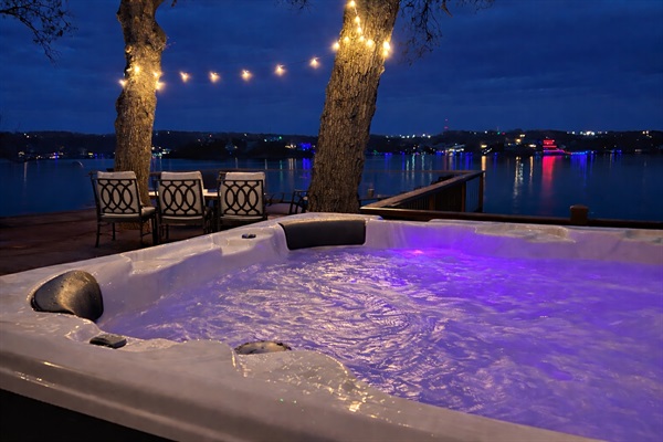 Soak in the hot tub under glowing lights and peaceful lake views