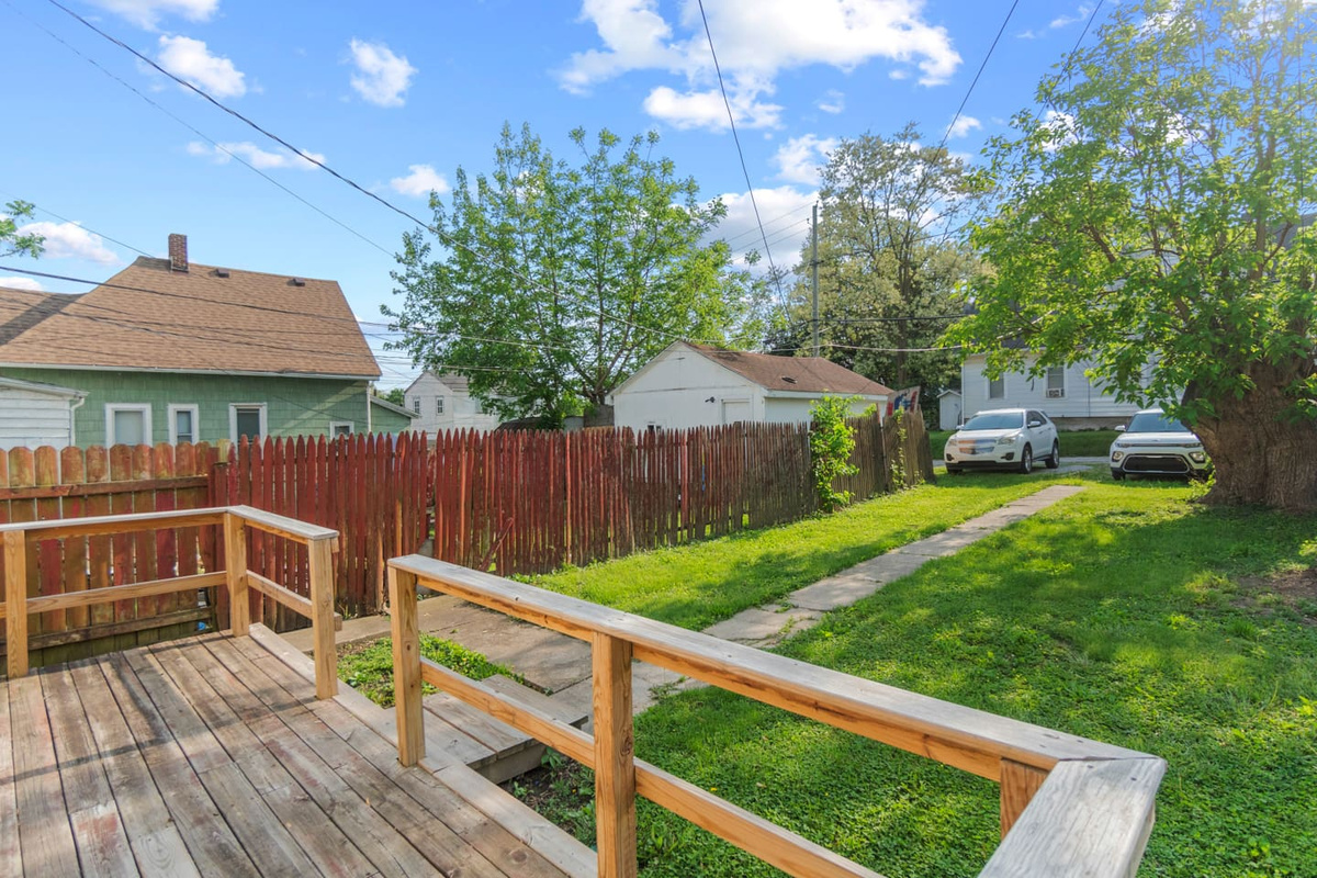 Outdoor deck with a spacious backyard and green surroundings.