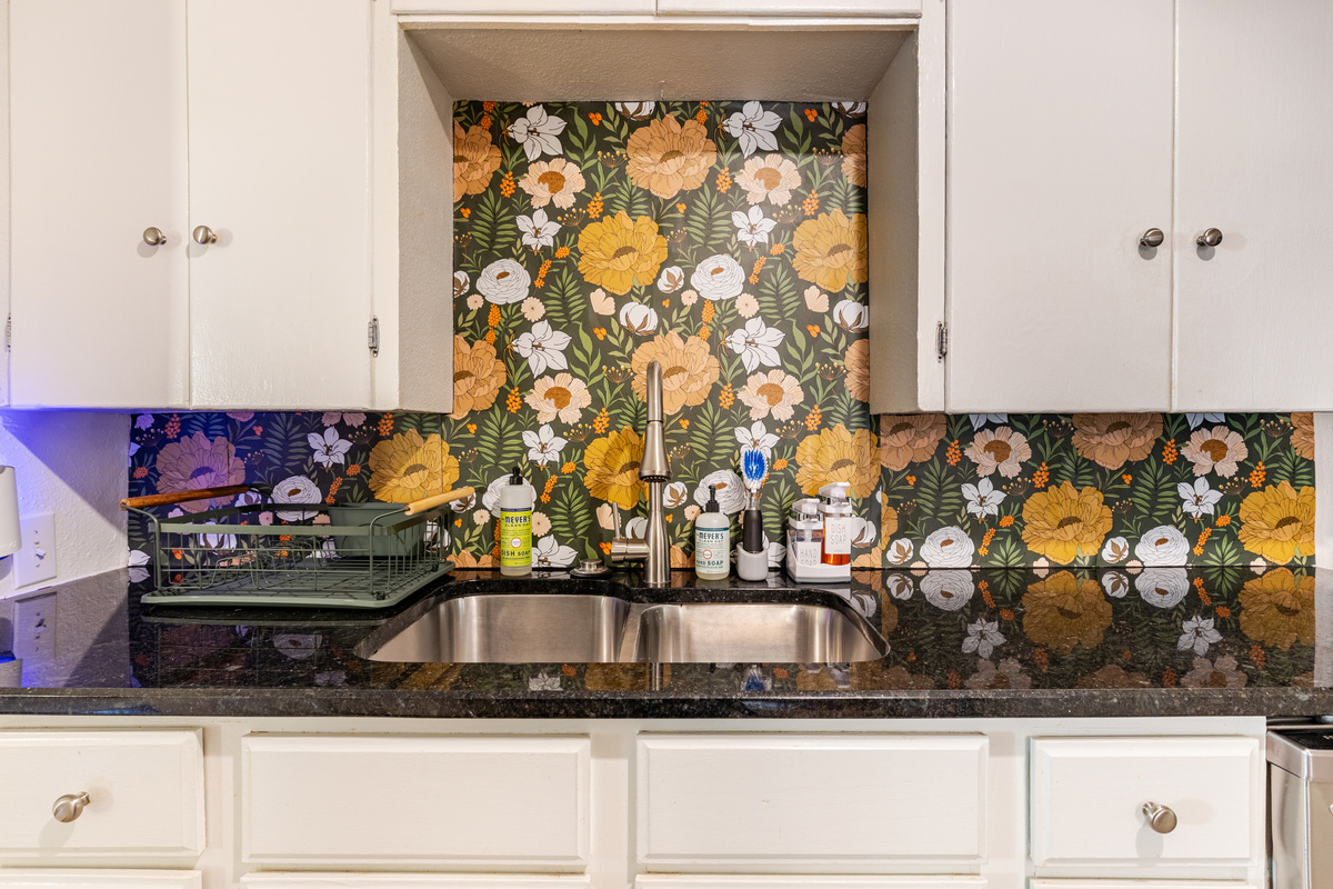 Bright floral backsplash and sleek countertops make cooking a joy!