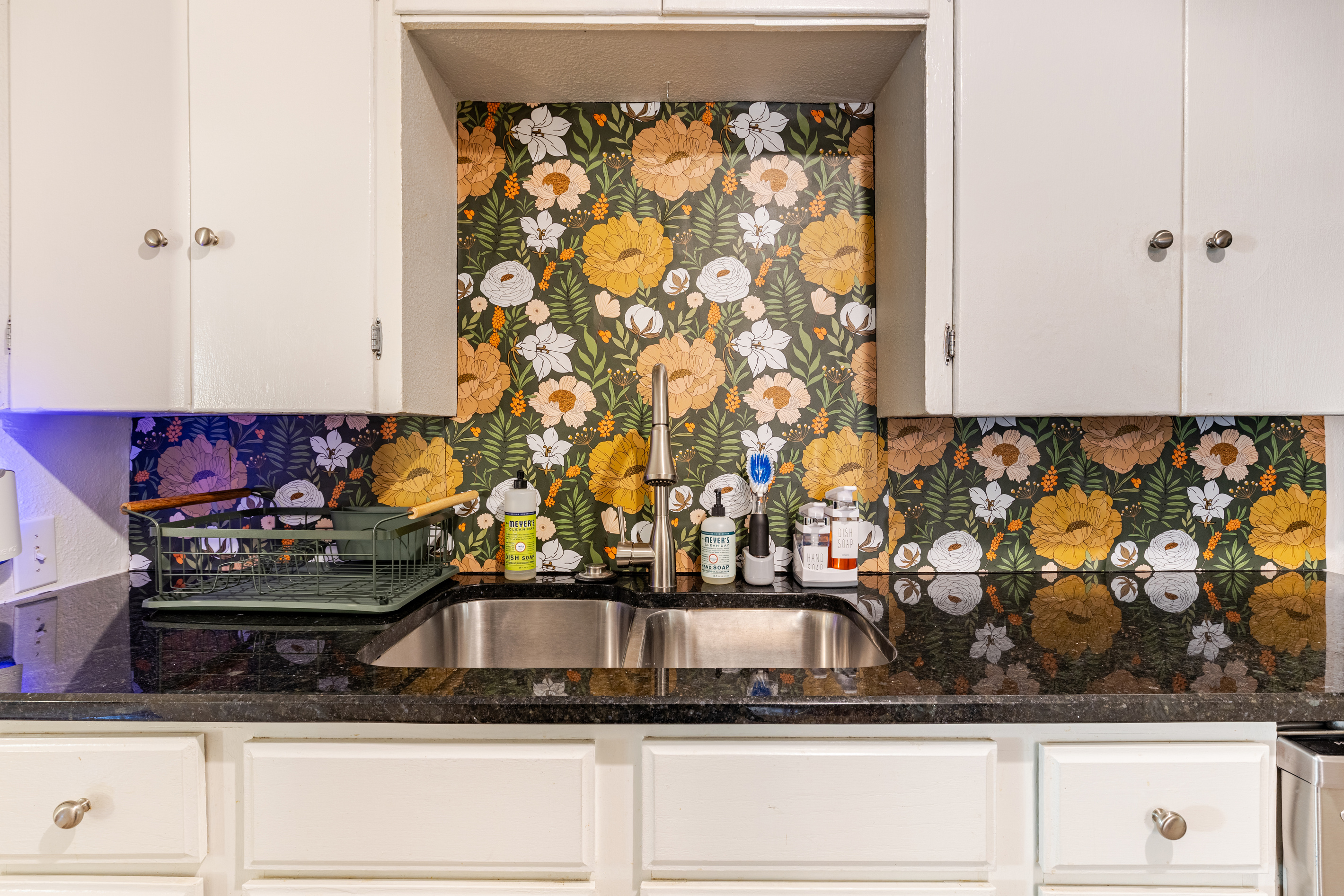 Bright floral backsplash and sleek countertops make cooking a joy!