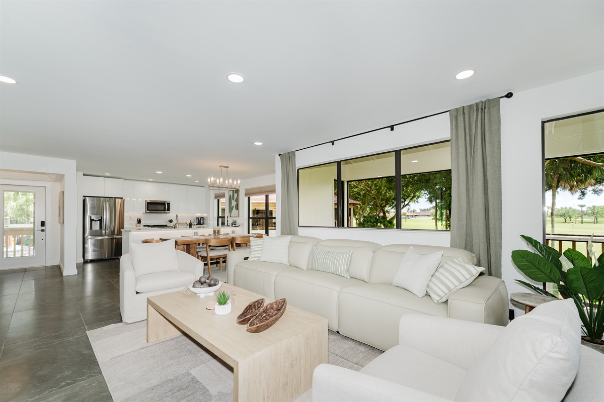 Bright, open living space filled with natural light and golf course views. Comfortable seating is perfect for relaxing after a day at the beach or golf. A spacious living area designed for both comfort and style.