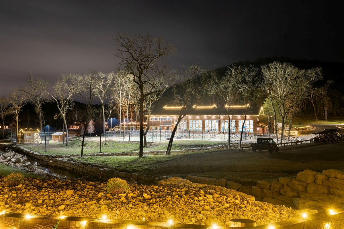 A peaceful nighttime setting with the cabin glowing among the trees.