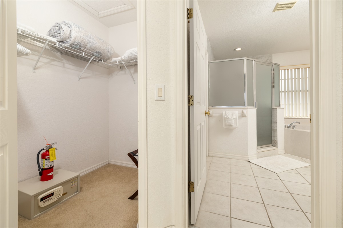The huge walk-in closet with a hotel style safe and luggage stands.