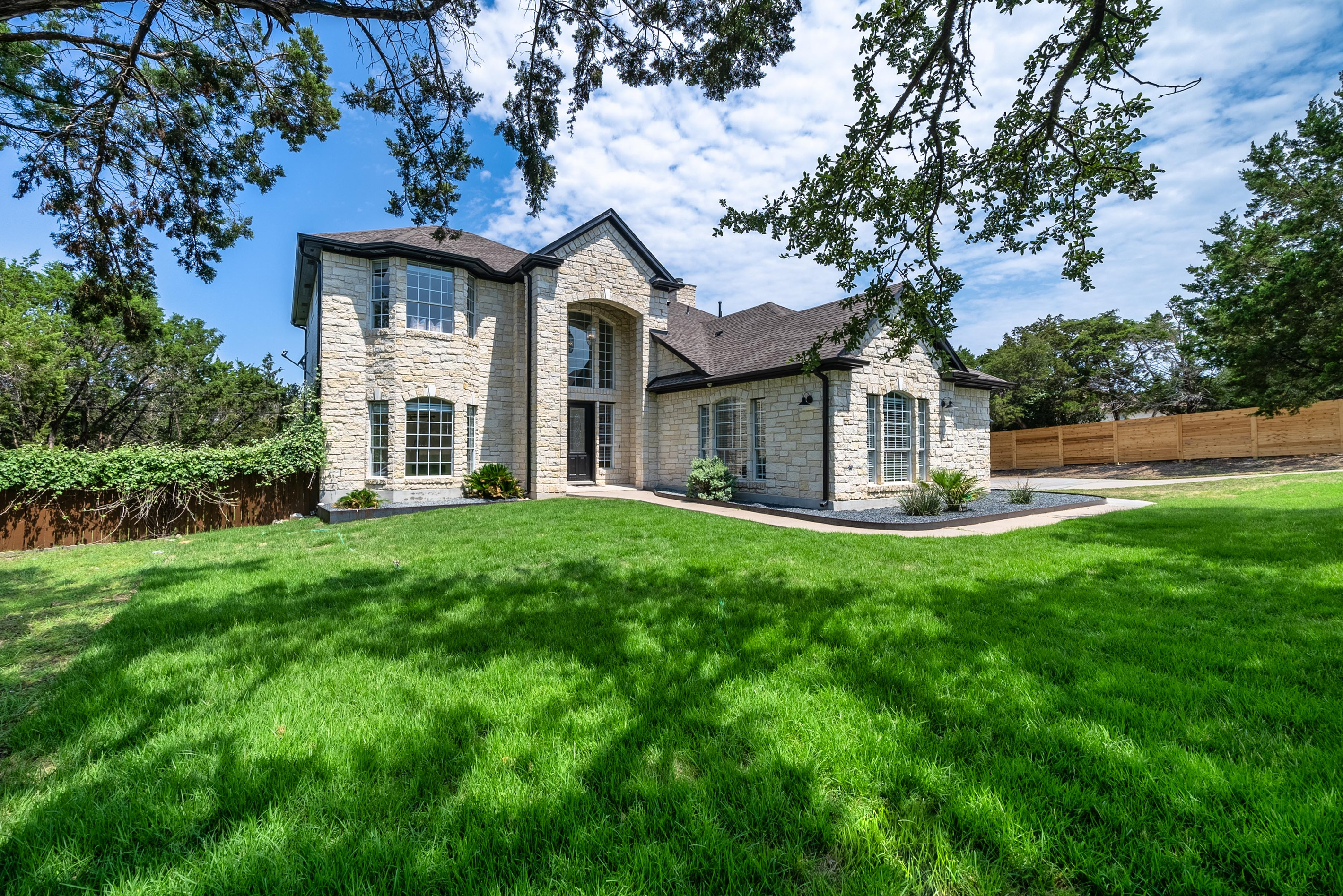 Elegant curb appeal with soaring windows and manicured landscaping.