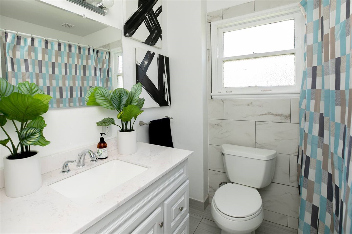 Bright, modern full-bathroom, geometric shapes and lines, granite vanity.  Enjoy a luxurious shower after a day at famous Huntington Beach