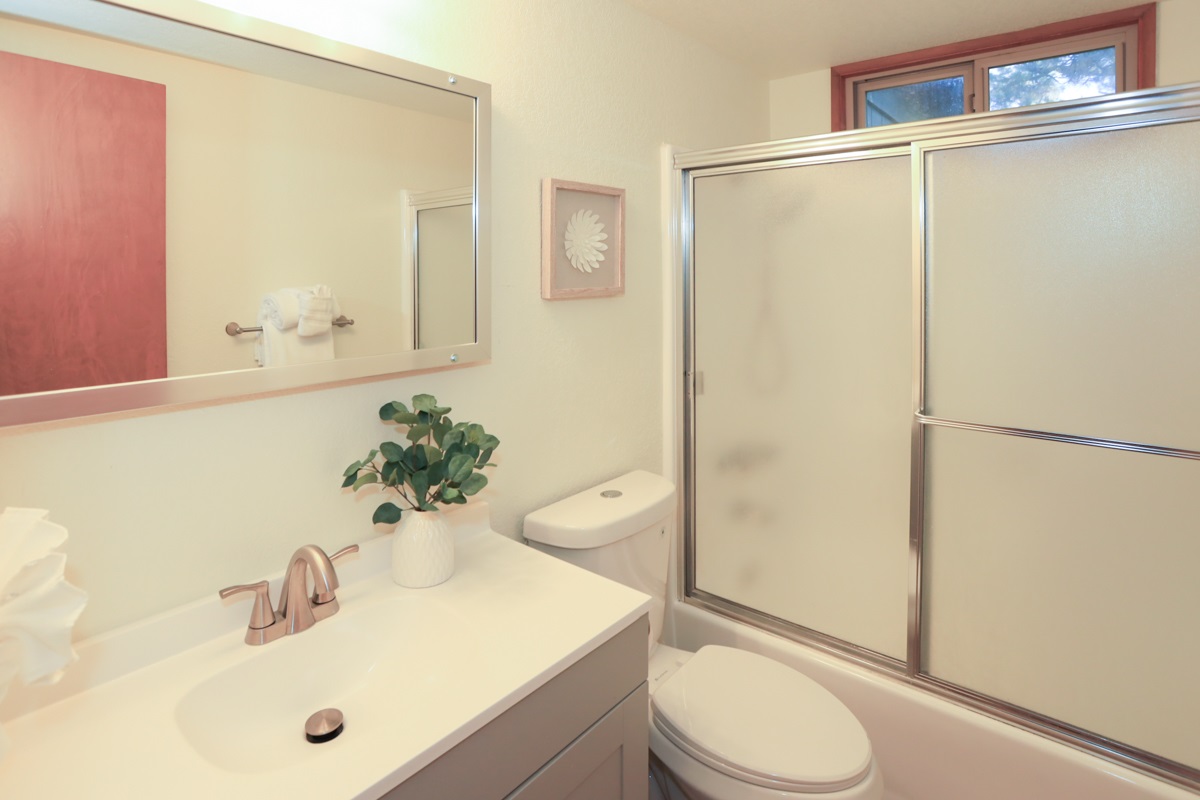 Bathroom 1 downstairs to the right, is full shower/tub combo with room to stow your toiletries under the sink.