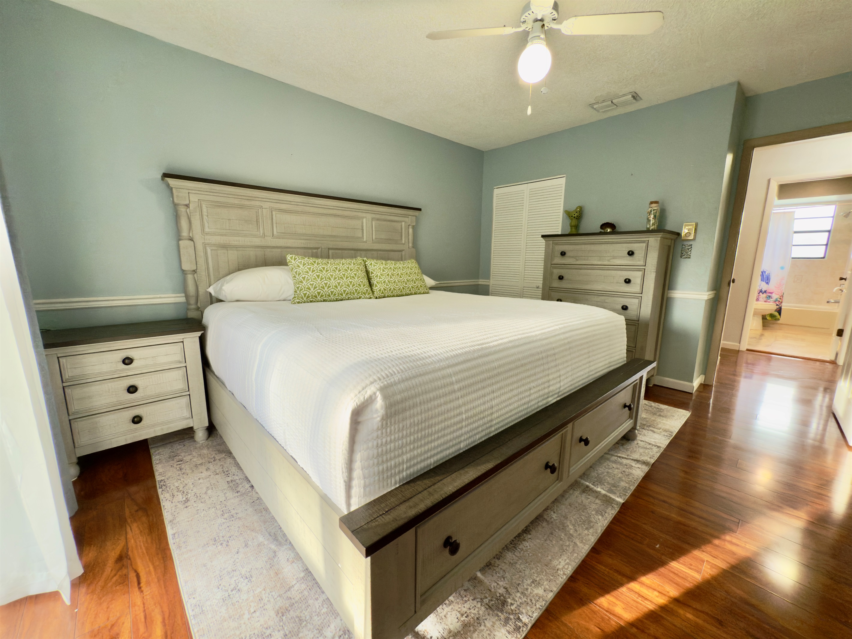 Featuring a sumptuous king-size bed with a detailed wood-paneled headboard and coordinating bedside tables.