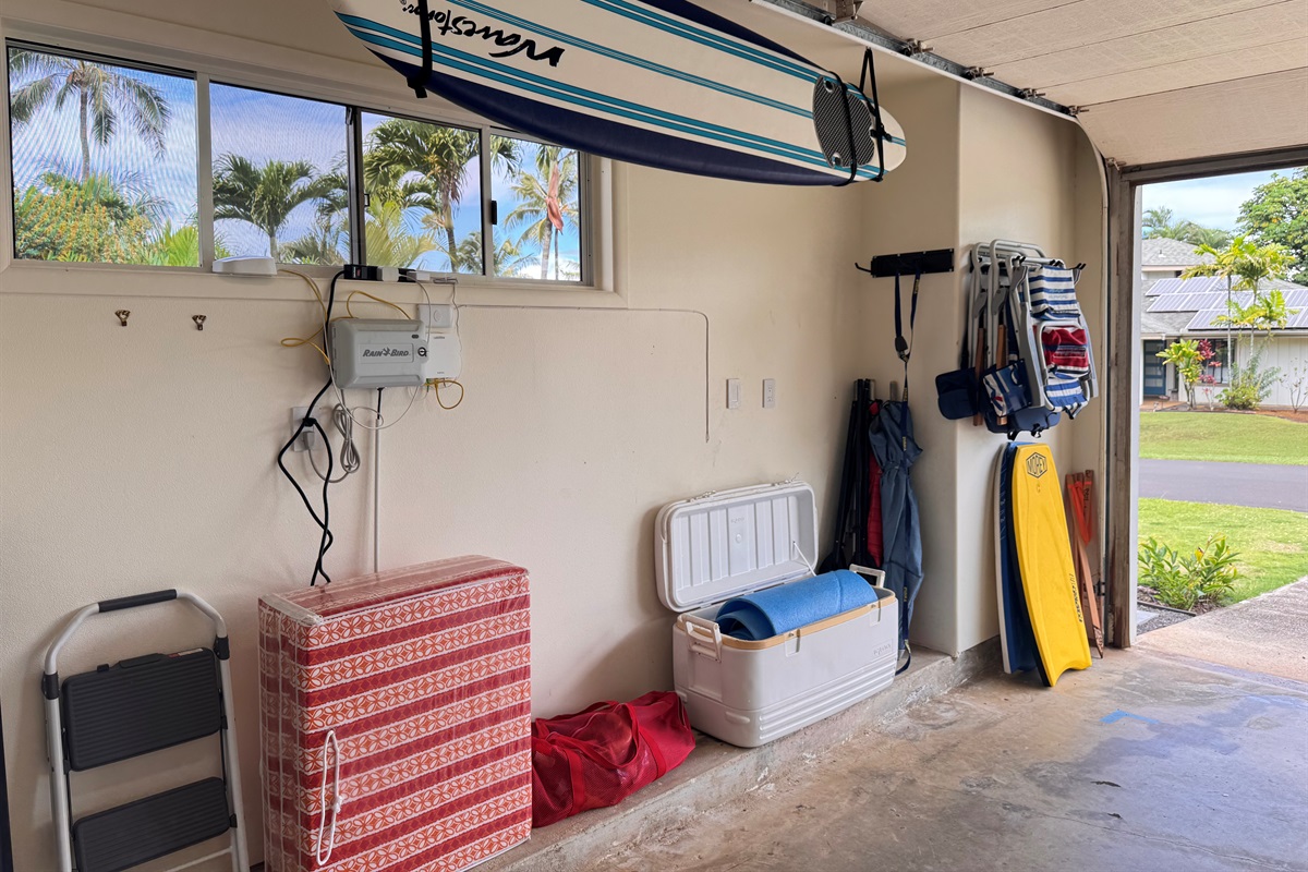 View of garage with chairs, Boogey boards, and surfboard