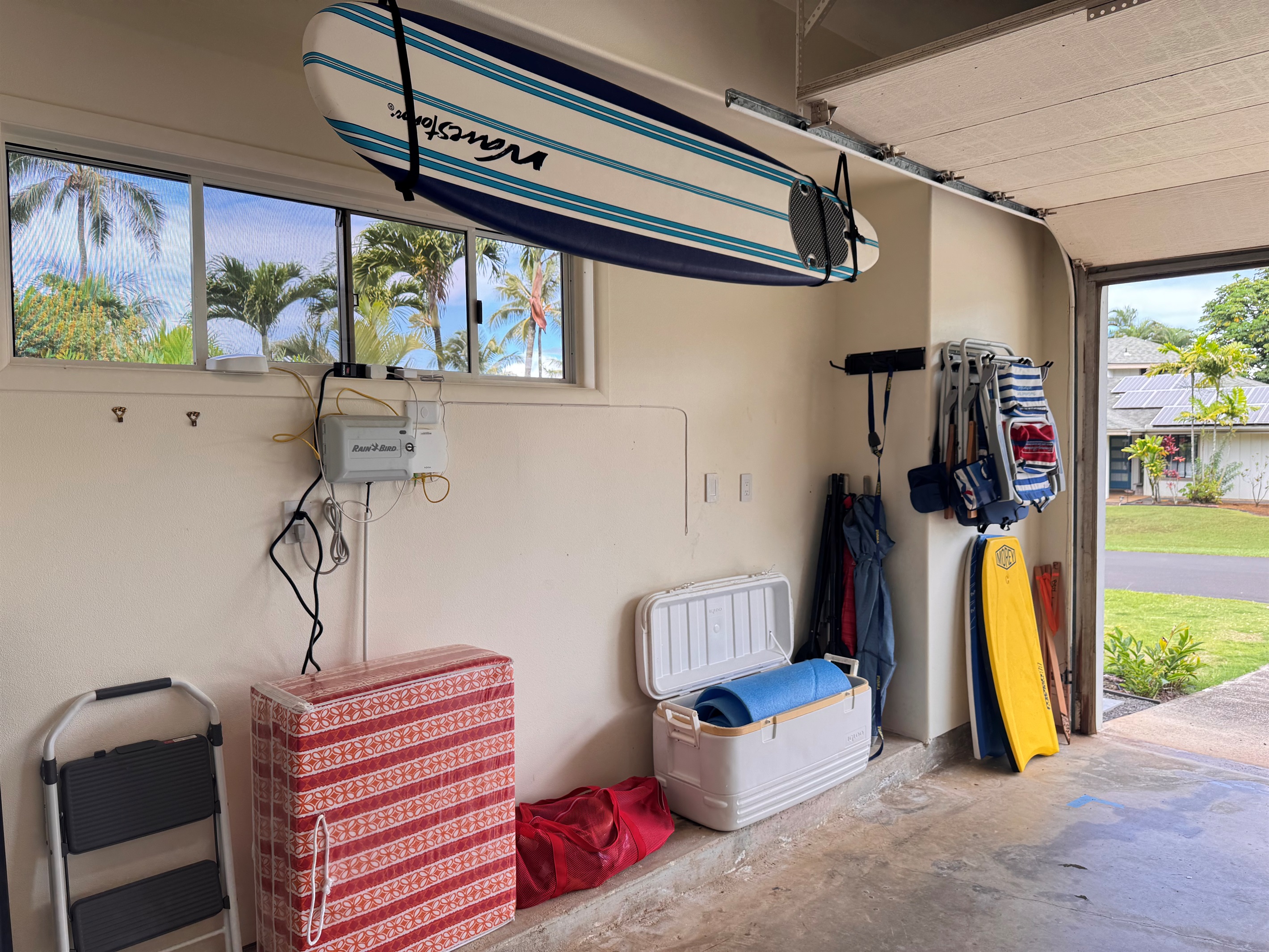 View of garage with chairs, Boogey boards, and surfboard