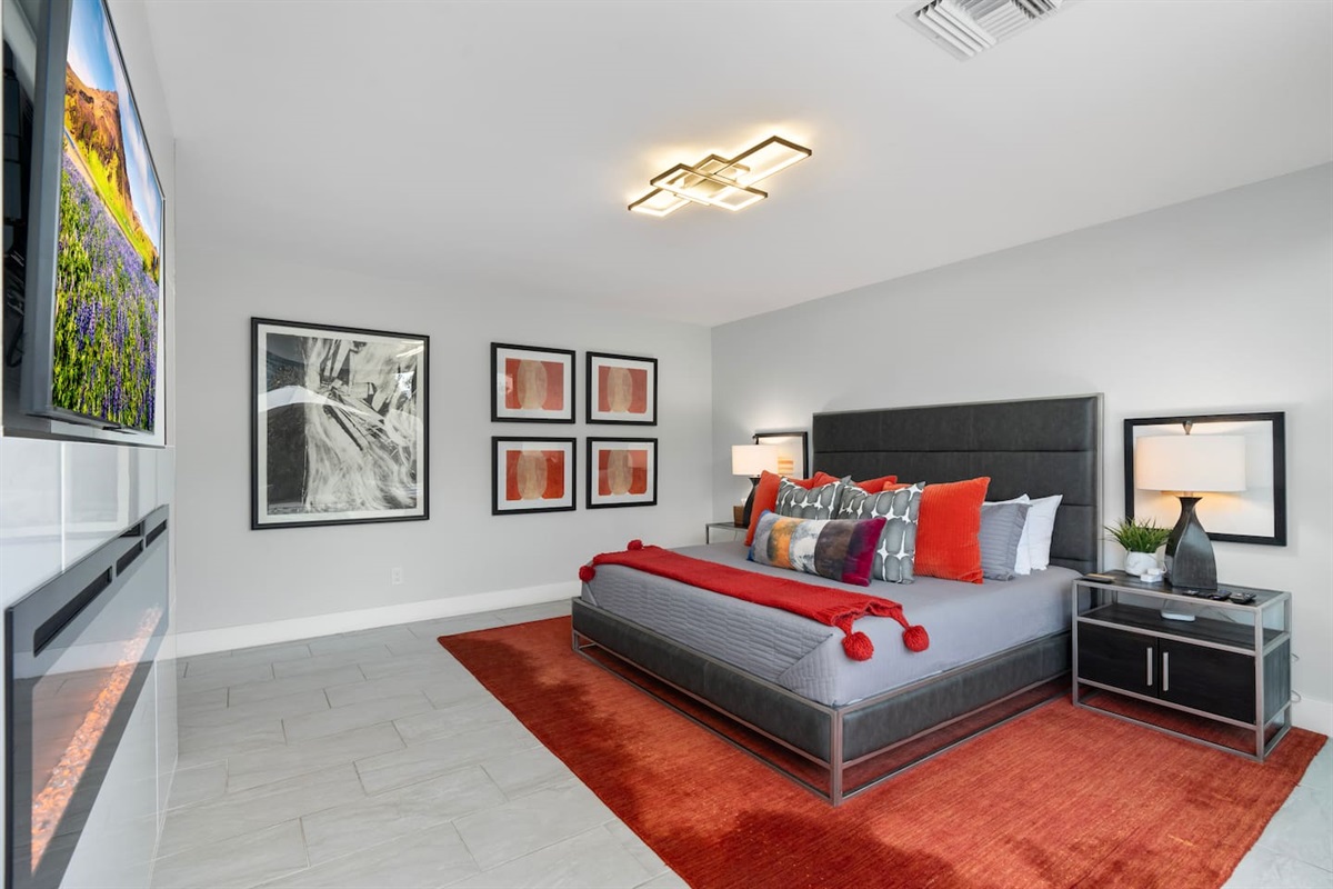 Sink into this striking king-size bed adorned with plush pillows and a cozy red throw, framed by sleek modern nightstands and moody lighting.