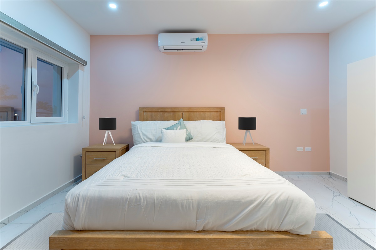 Close-up of the queen bed with warm-toned linens and built-in drawers for storage