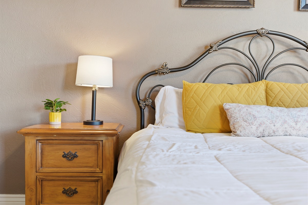 Sleep soundly in this cozy king bedroom with soft bedding and calming light.