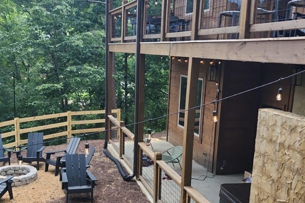Spacious balcony with outdoor seating, nature views, string lights, fire pit, mini golf, and hot tub.