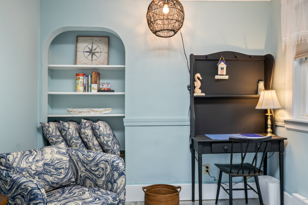 An office nook and dedicated workspace off the main floor, The Compass Den includes a desk setup, storage shelving, and accent seating. A second full-length mirror provides an efficient getting-ready station to help groups prepare for the day.