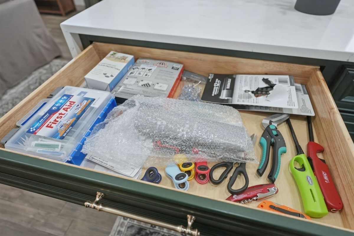 Handy household drawer with a first aid kit, scissors, lighter, and other useful items for added convenience during your stay.