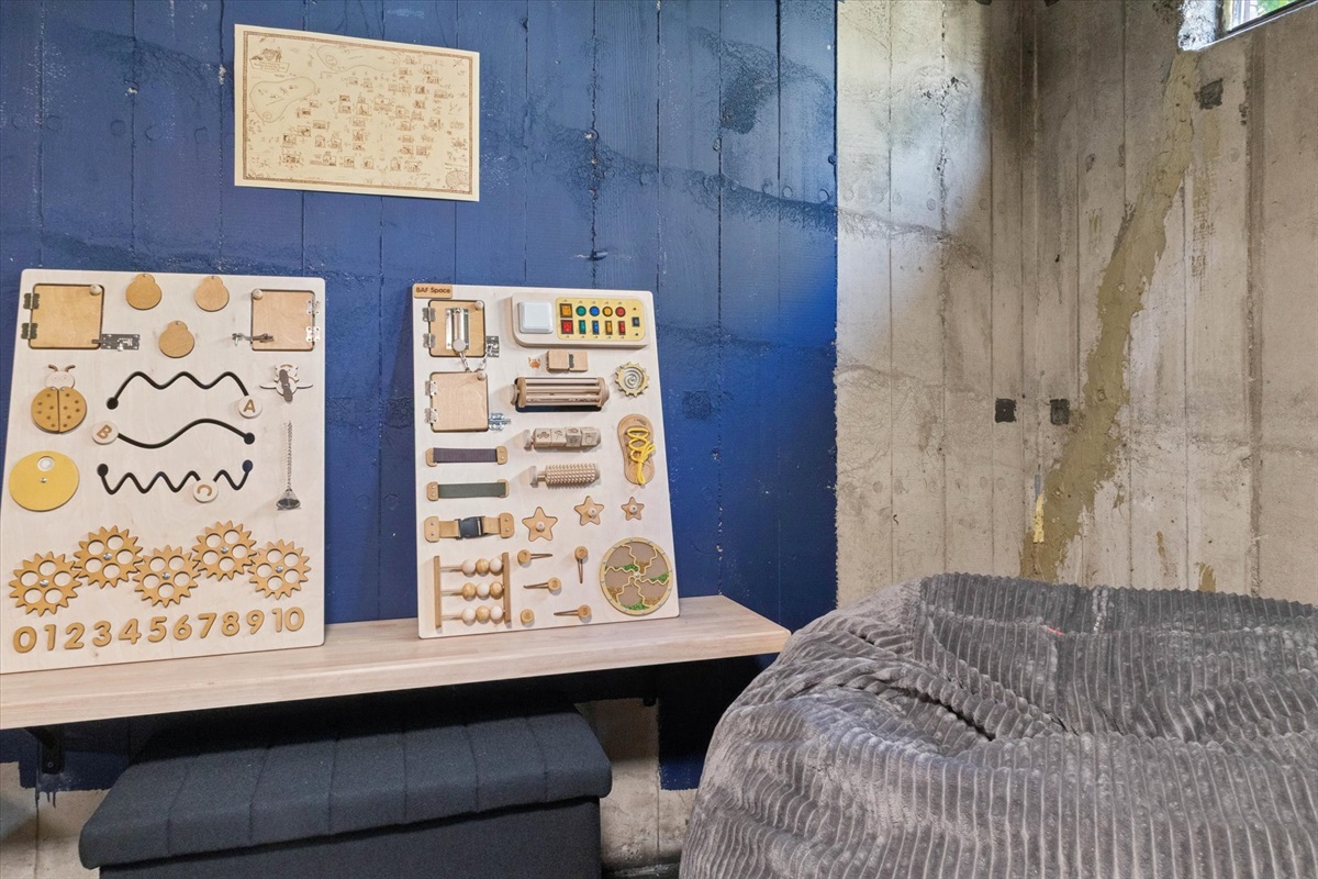 Sensory boards, a vintage ND campus map, and an oversized bean bag chair anchor our basement play zone—a cozy South Bend retreat near Notre Dame, built for imagination and family fun.