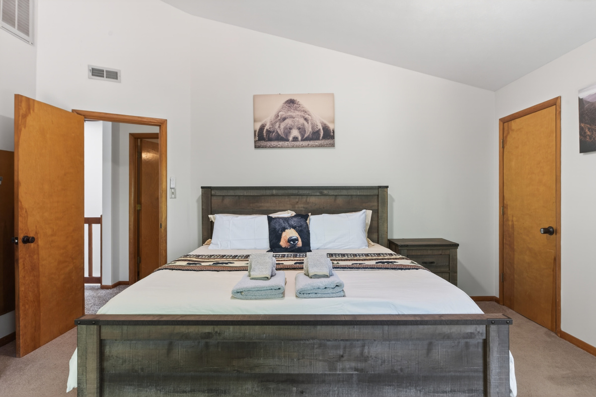 Bedroom 1 Retreat: Delight in rustic charm with a plush bed and playful bear decor!
