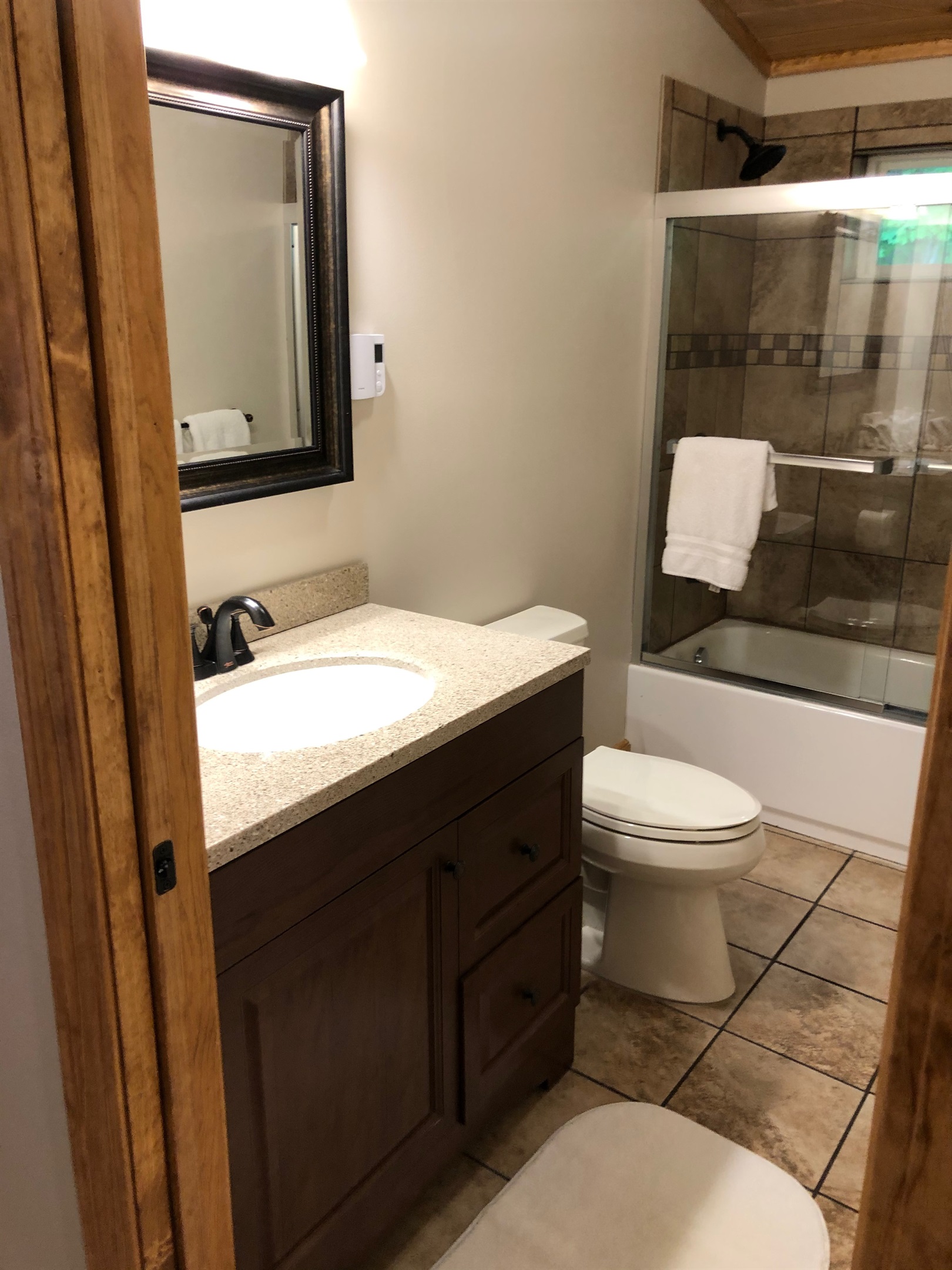 Hallway bathroom with glass shower doors.