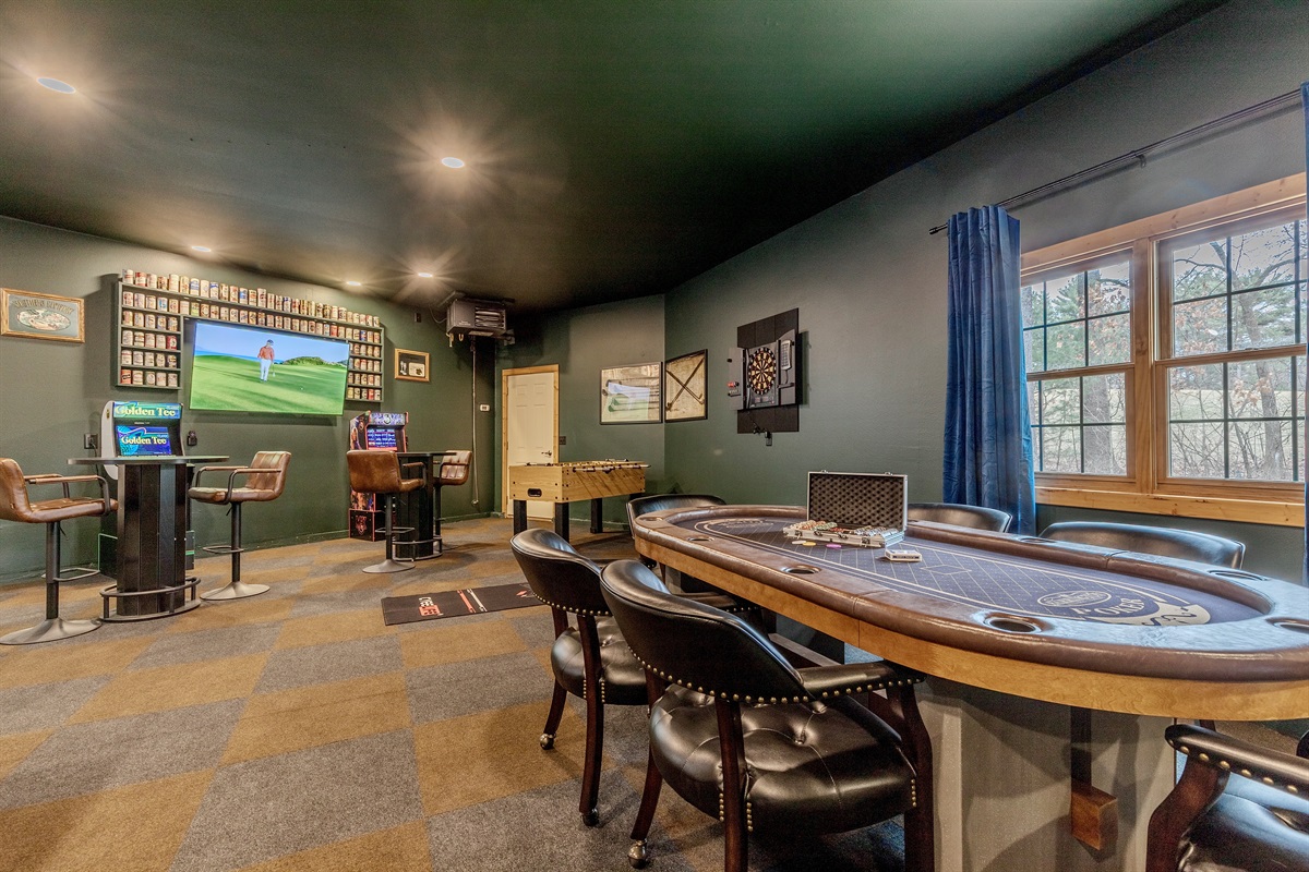 Check out this garage made game room.  Equipped with air hockey, 6-person poker table, putting green, arcade games, dartboard, foose ball and two smart TVs.