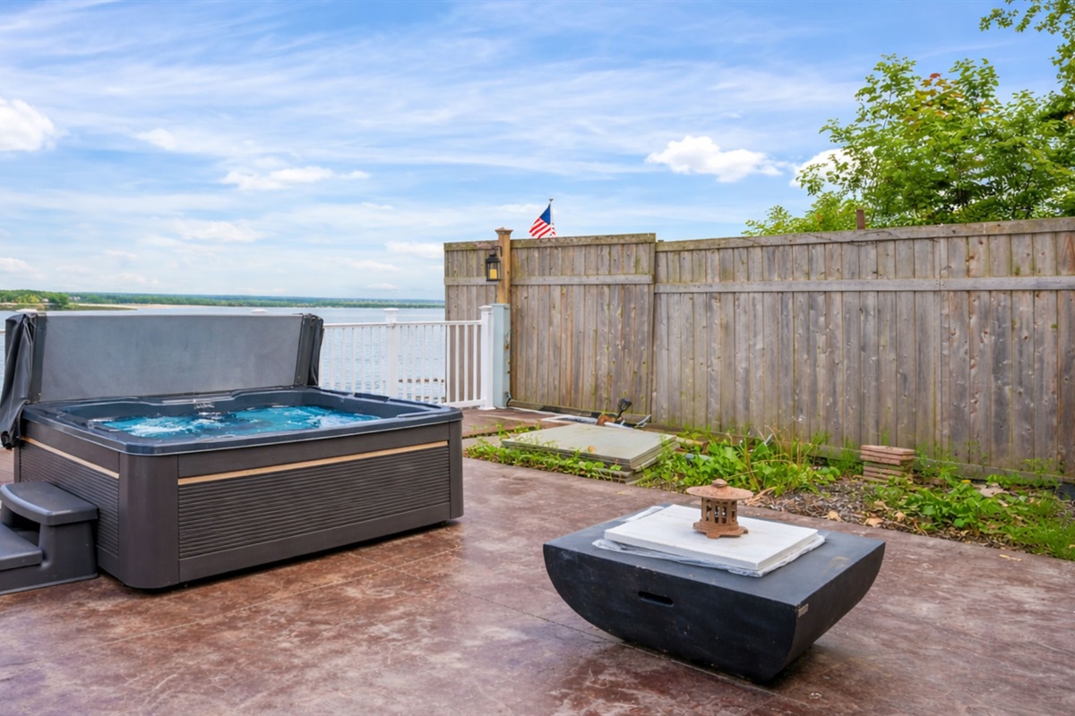 Unwind in the lakeside hot tub with endless water views and a cozy fire table to set the mood 🌊🔥🛁