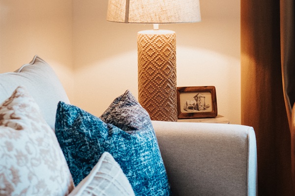 Layered pillows, warm lamplight, and handcrafted details in the Cutter's Quarters living room &mdash; modern-Western without the clich&eacute;.