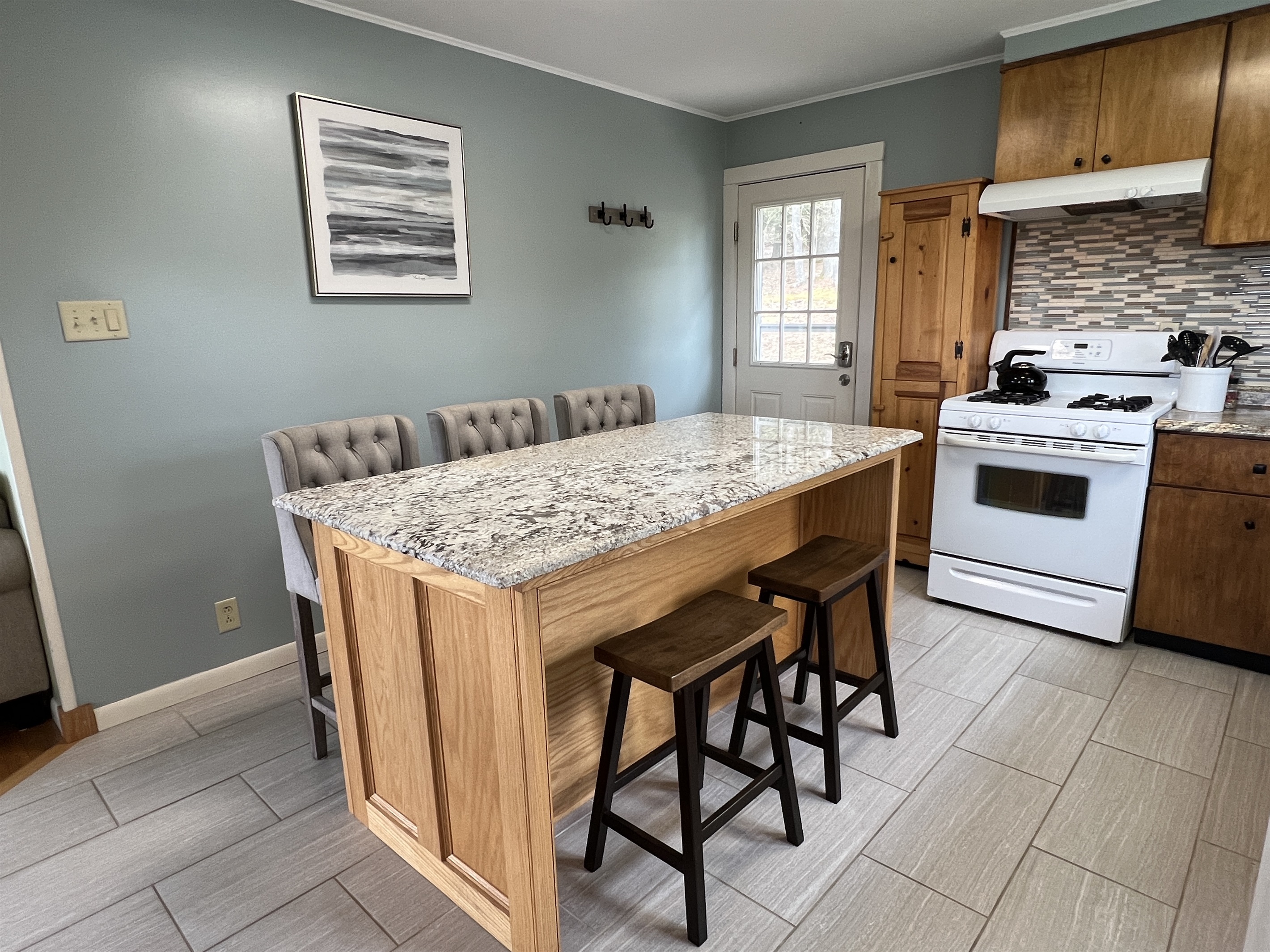 Plenty of seating at the kitchen island. The door leads to the back deck, easy access to the grill.