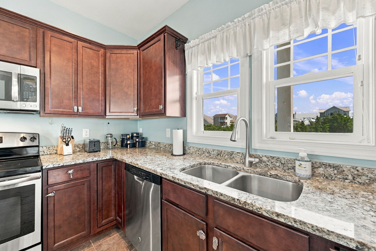 Spacious kitchen countertop and double-basin sink with beautiful natural light and scenic neighborhood views