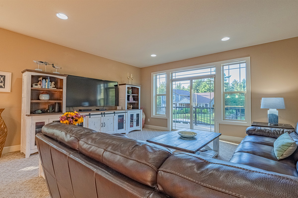 Comfy family room off kitchen.  Leather sectional sofa, 75" TV w/cable, DVD player w/movies.