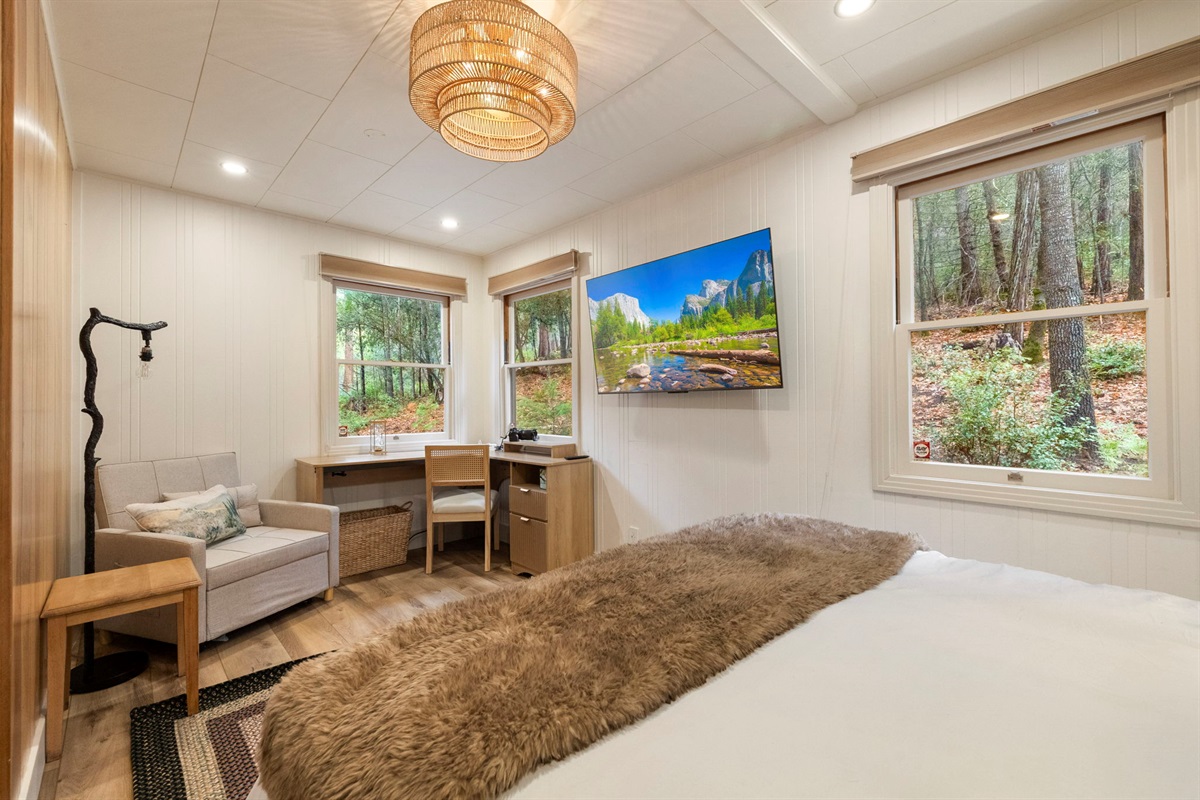 Master bedroom with a fandalier, queen memory foam mattress and separate work/relax area within the room.
