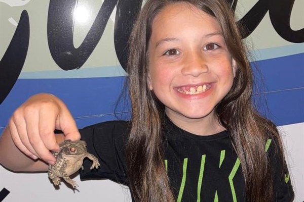 Catching a frog makes a young man smile!