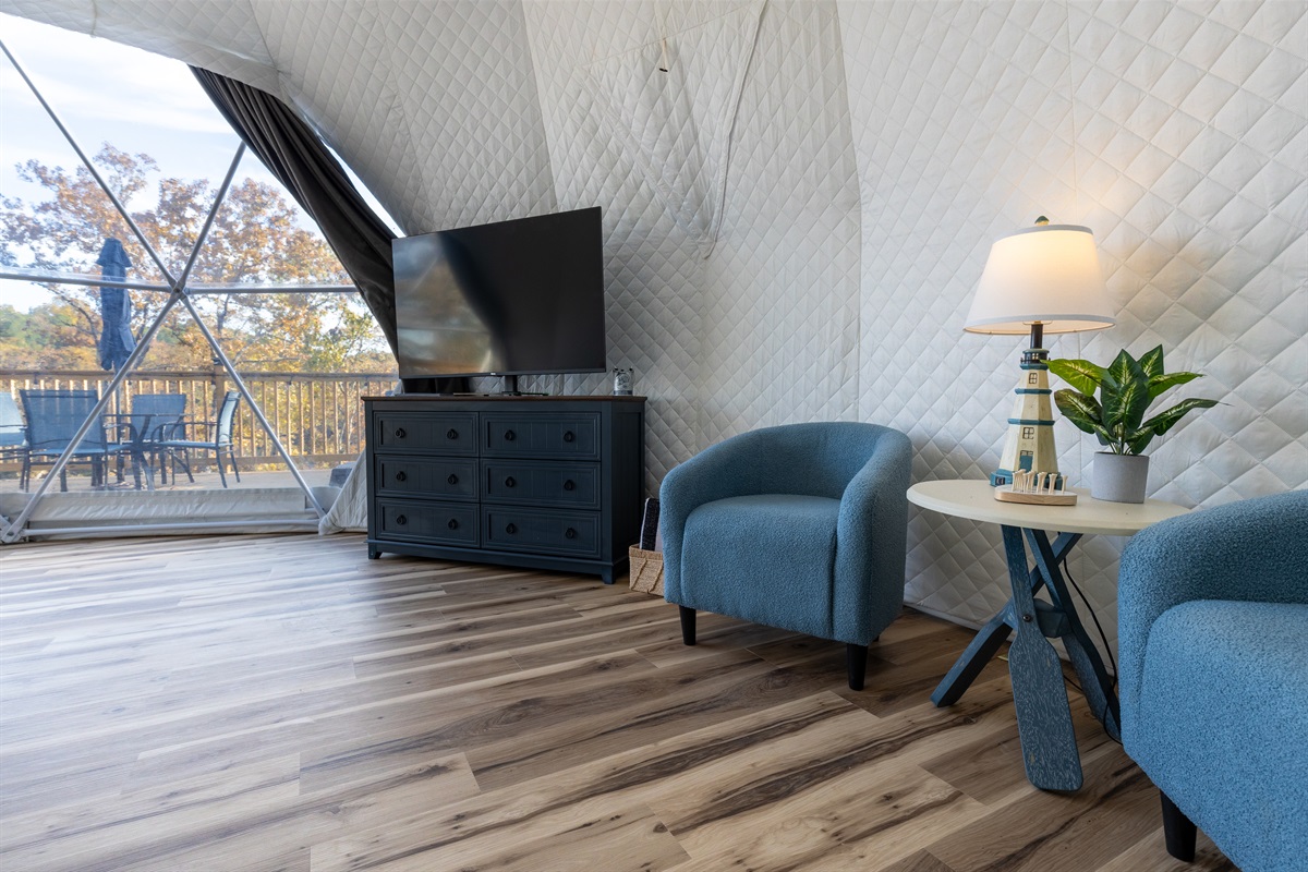 Cozy lounge area with plush chairs, smart TV, and charming nautical décor — perfect for relaxing after a day on the lake