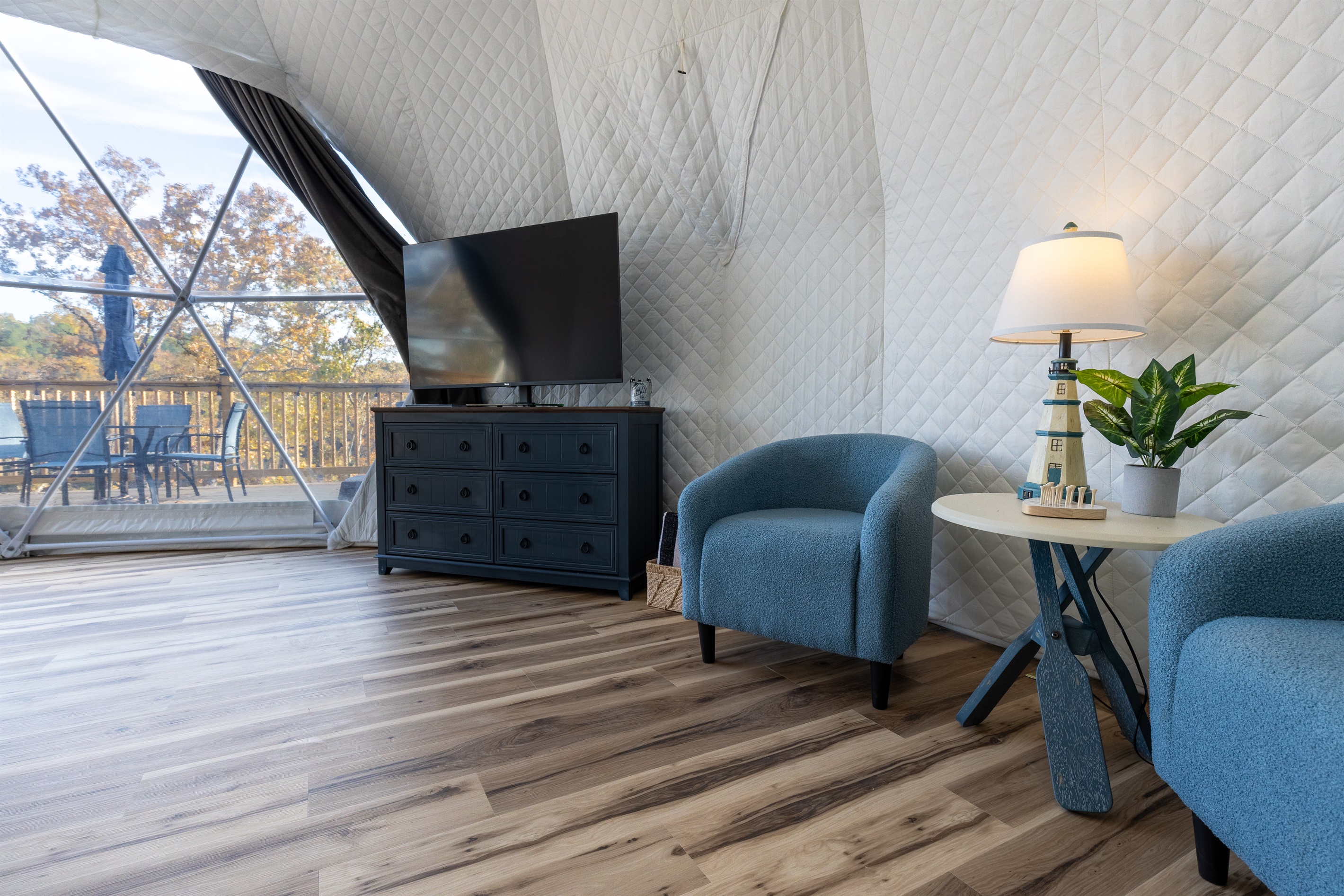 Cozy lounge area with plush chairs, smart TV, and charming nautical décor — perfect for relaxing after a day on the lake