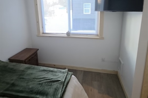 Bedroom on main floor includes a queen size bed, nightstand, closet and TV [Photo is representative but is not from this cabin].