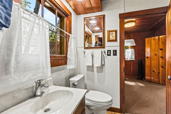 The bathroom offers fresh towels, a full tub and shower, and bright natural light to start your day refreshed.