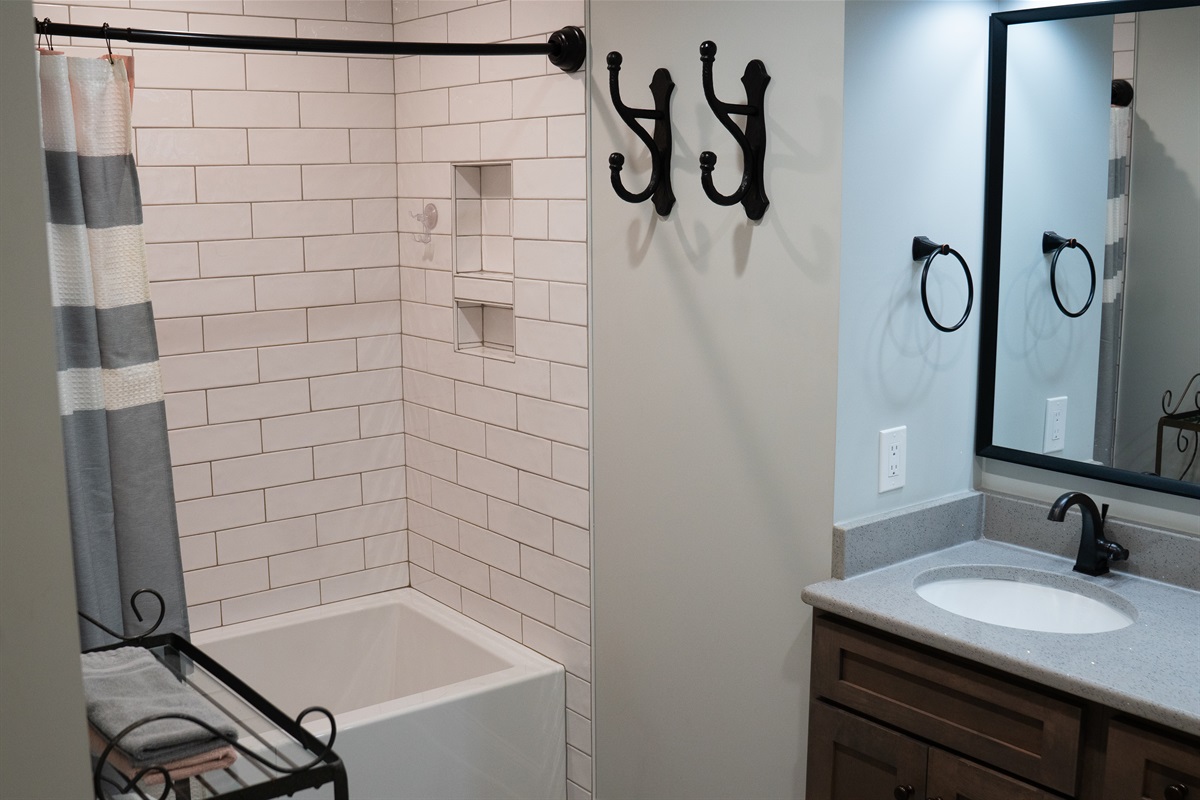 The bathroom includes a tiled tub/shower combo, offering both style and functionality.