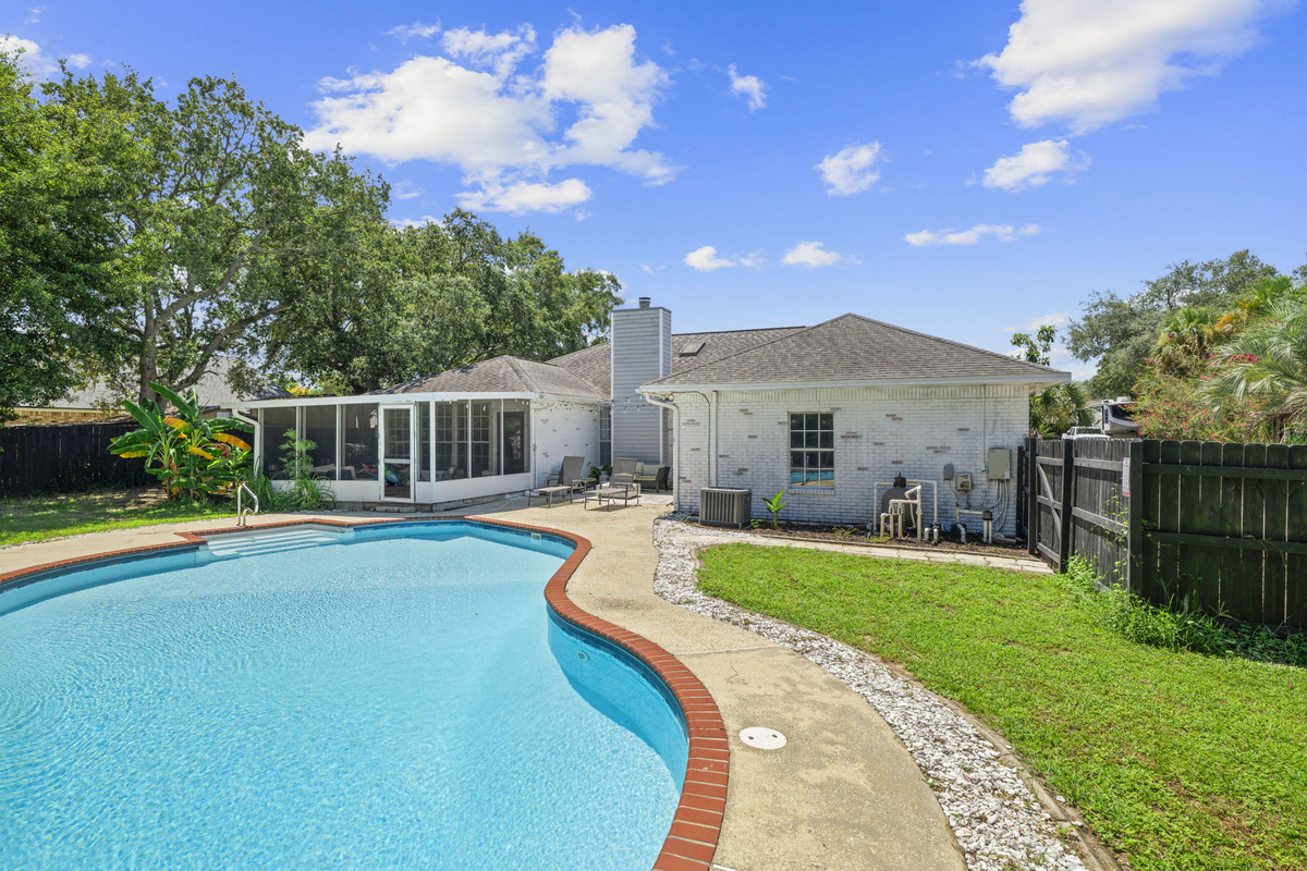 Sunny days call for poolside lounging in this spacious, fully fenced backyard retreat.