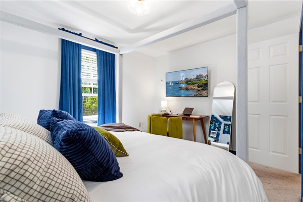 A well-appointed bedroom featuring a comfortable bed and a functional workspace, offering the perfect balance of rest and productivity in a calm, inviting setting.
