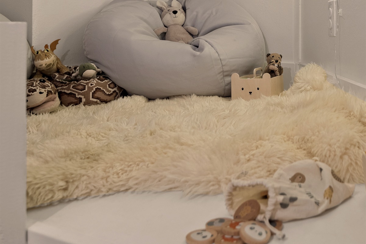 Soft, cozy kids’ corner with plush seating and warm lighting—an inviting space for playtime or quiet moments.