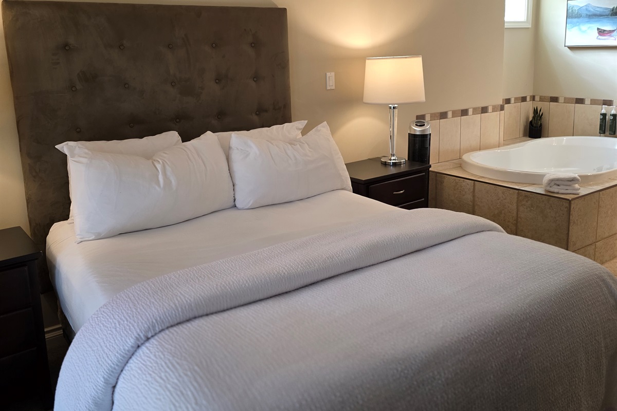 Unit A Primary Queen Suite with soaker Tub and glass doors to patio.