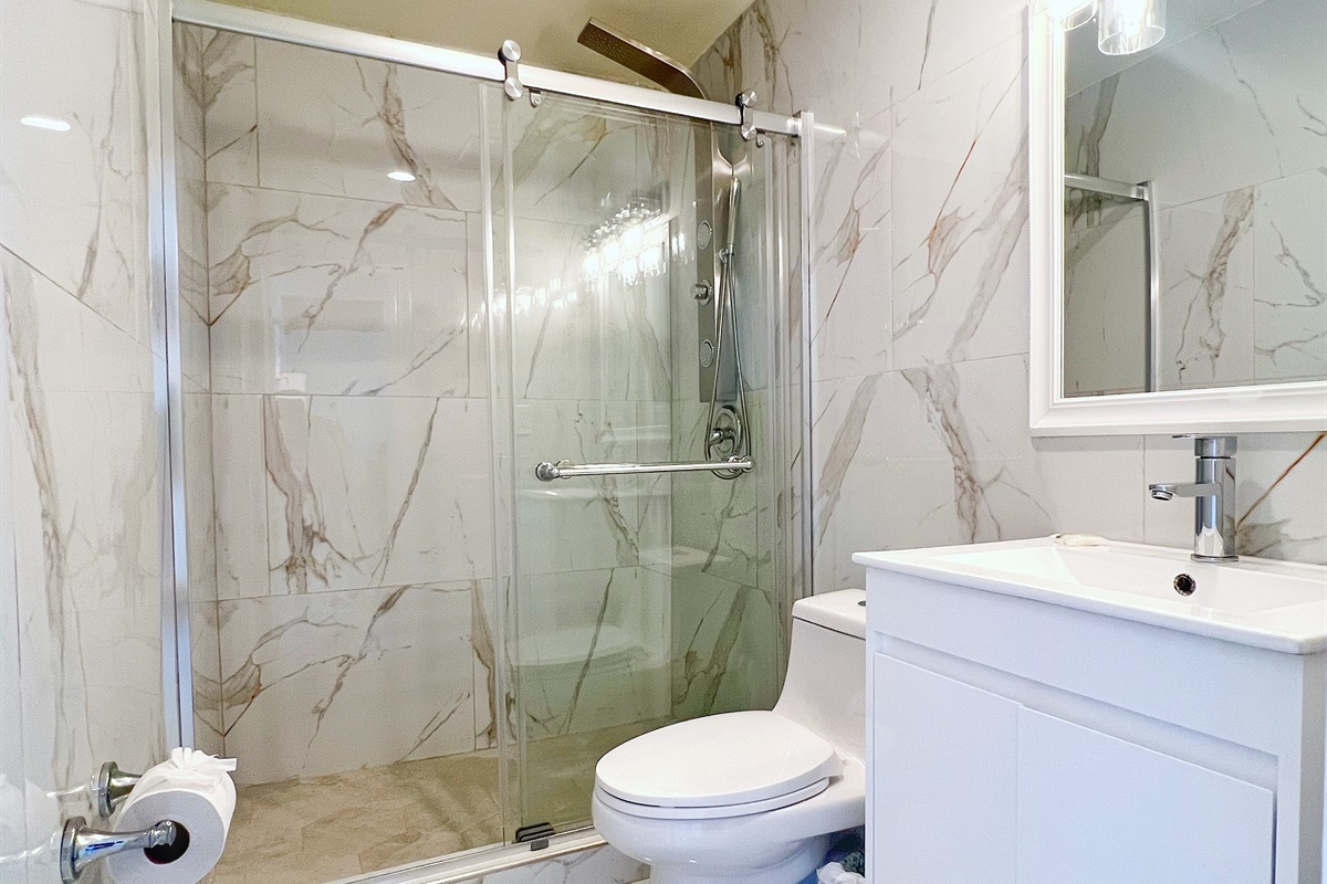 Modern bathroom with shower and elegant tile finishes just off the living room