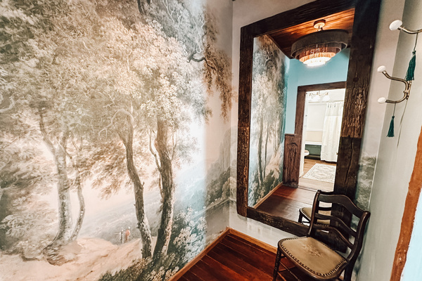 A jewel-box dressing room wrapped in a dreamy woodland mural, with a full-length mirror and direct passage from the first-floor primary to its private bath. Because even getting dressed should feel like part of the escape.